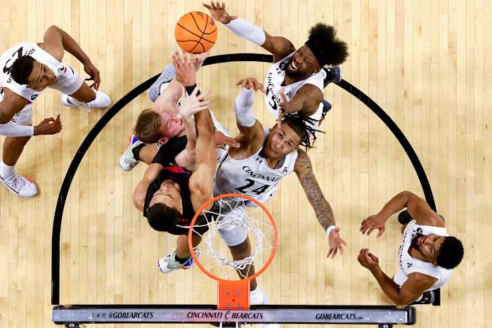 Cincinnati Bearcats guard Jeremiah Davenport (24), Cincinnati Bearcats center Hayden Koval (25) and Cincinnati Bearcats forward John Newman III (15) compete for a rebound against Southern Methodist Mustangs forward Tristan Clark (25) in the first half of an NCAA men s college basketball game, Thursday, Jan. 6, 2022, at Fifth Third Arena in Cincinnati. The Cincinnati Bearcats defeated the Southern Methodist Mustangs, 77-60. Southern Methodist Mustangs At Cincinnati Bearcats Jan 6 Smu